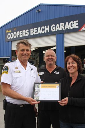 AWARD: Cooper's Beach Garage proprietors Ray and Angela Dare receiving their certificate of appreciation from St John northern region operations manager Mike Burrows. 
